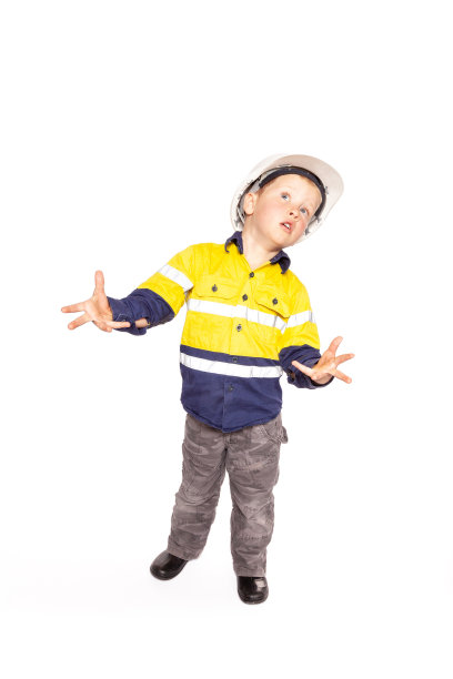 年轻的金发白人男孩双手伸展，扮演一个沮丧的建筑工人主管，穿着黄蓝相间的衬衫，靴子，白色安全帽，没有锤子和卷尺。图片下载