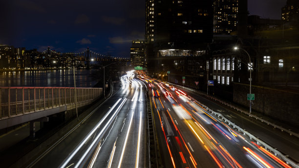 罗斯福时期曼哈顿上东区繁忙的夜间交通。罗斯福岛和埃德·科赫皇后大桥的远景。模糊的运动效果。图片下载