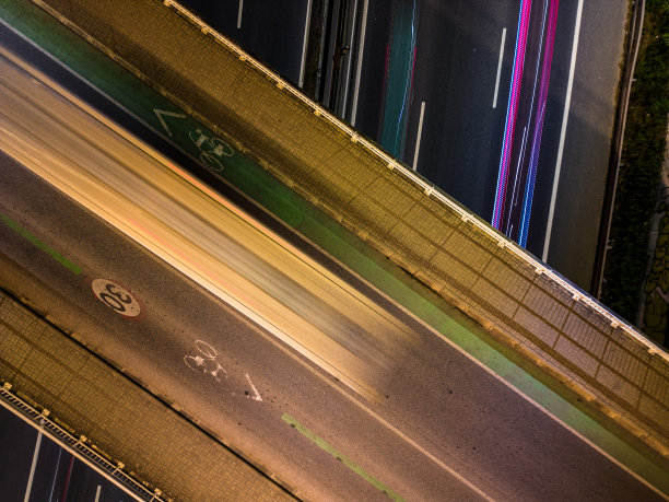 空中无人机的天空视图拍摄的交通在里斯本在夜间与五颜六色的光轨迹图片下载