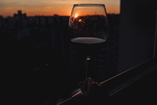 日落时分手握酒杯。图片下载
