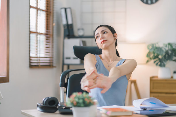 一位迷人的千禧一代女商人在她的家庭办公室休息时伸展双臂。图片下载