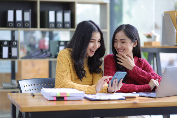 快乐的女同事一起用手机自拍。图片下载
