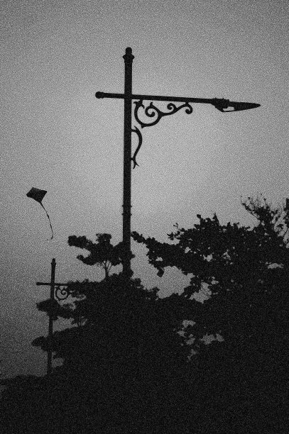 公园街灯柱和风筝在天空中飞翔的剪影照片。图片下载