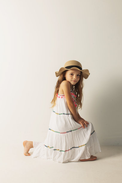 金发女孩在白色背景的白色连衣裙和帽子的工作室。风格图片下载