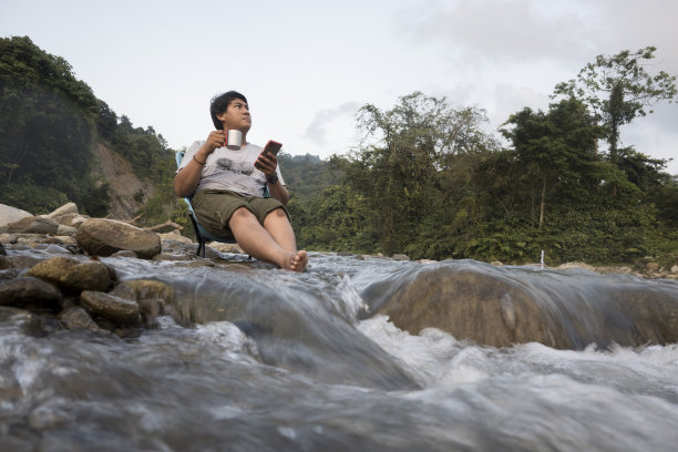 男人在享受咖啡和玩手机时放松-资料图片图片下载