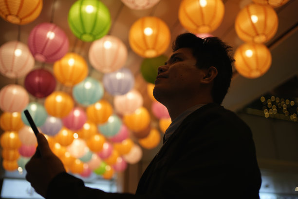 这名男子在景观灯下使用手机图片下载