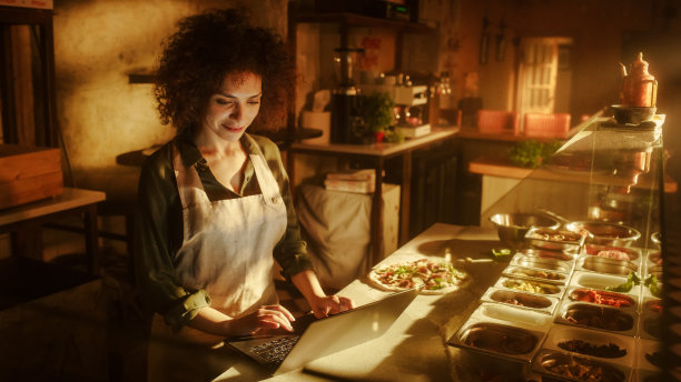 在餐厅:美丽的女厨师使用数码平板电脑。正宗的披萨店与美味的有机生态食品。双种族女企业家在她的小生意家庭商店工作图片下载