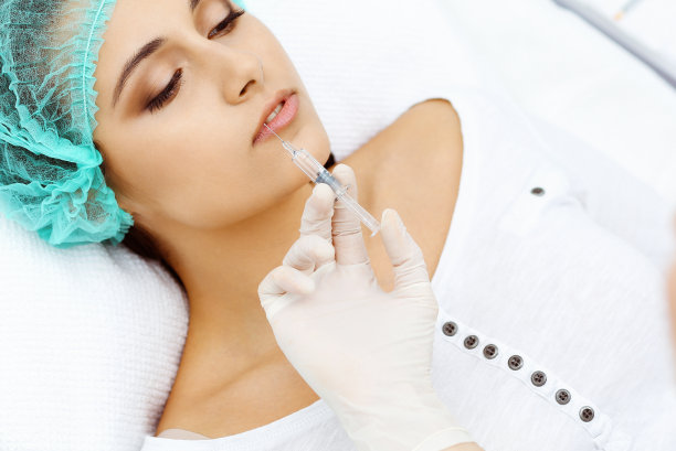 专业美容师做面部、唇部注射。年轻女子得到注射器填充面部轮廓或增强。面部老化，年轻化和水化程序图片下载