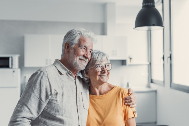 梦幻的中老年恩爱的退休夫妇遥望远方，规划共同的未来或回忆，享受一起站在客厅放松的宁静时刻图片下载