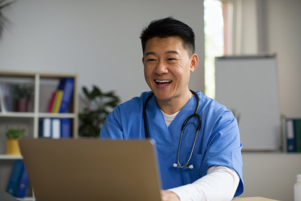 微笑的中年亚洲治疗师在工作场所在电脑聊天，在线咨询，有视频电话图片下载