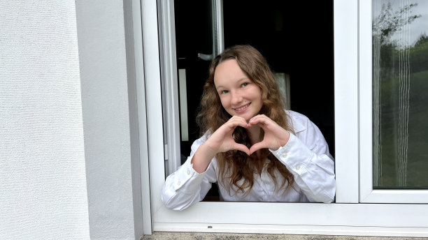 白色背景上的一个女孩，穿着白色衬衫，金发，表现出不同的快乐情绪，她做鬼脸，她开心地笑，她弄乱头发，露出舌头图片下载