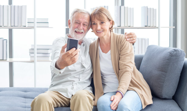 老年夫妇在用智能手机自拍时玩得很开心。幸福。退休。快乐有趣的成熟夫妇自拍看着智能手机图片下载