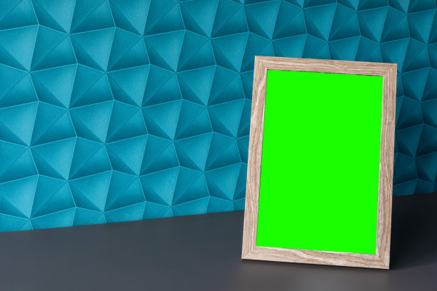 背景是蓝色的壁纸——色彩丰富的空间。木框:放在房间台面上的画框你自己的照片空间。图片编辑的绿色屏幕。图片下载