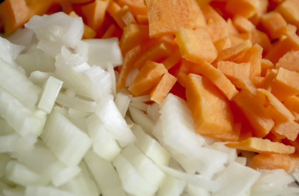胡萝卜和洋葱——背景照片。同样切碎的洋葱和胡萝卜。切碎的蔬菜——洋葱和胡萝卜背景图片。图片下载