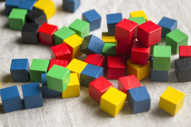 明亮的儿童方块。儿童用木头做的立方体。布料上的彩色方块。在桌子上有许多彩色的方块游戏。图片下载