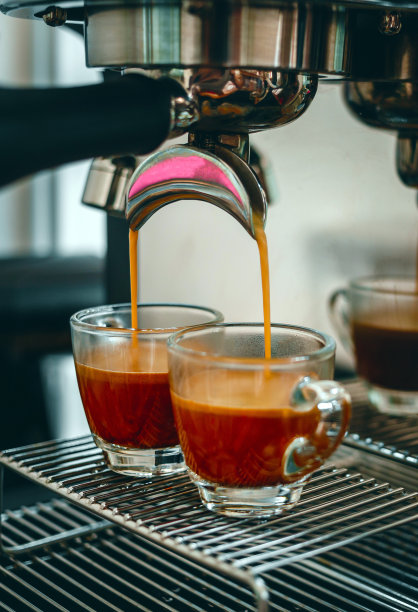 在咖啡店准备两杯浓缩咖啡时，专业的浓缩咖啡机。浓缩咖啡从咖啡机倒出来的特写镜头图片下载