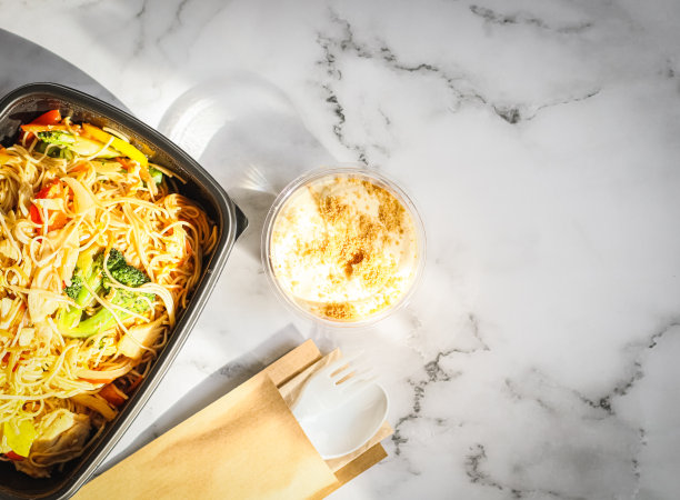 面条和蔬菜放在一个容器里，甜点放在桌子上。图片下载