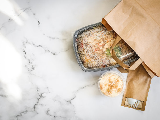 面条和蔬菜放在一个容器里，甜点放在桌子上。图片下载