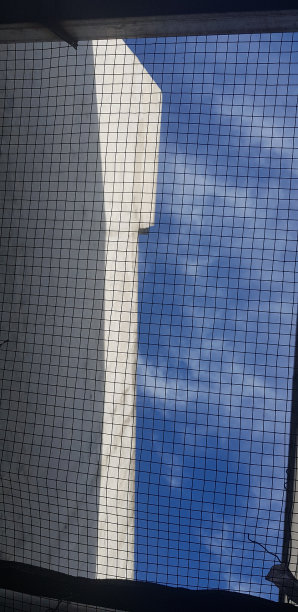 天空的背景照片，有铁丝网和白色的房子。V图片下载