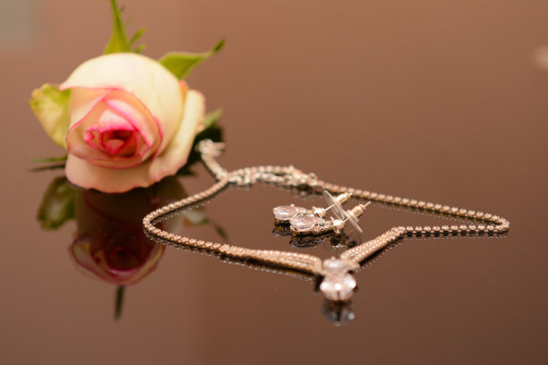 米色玫瑰和黄金项链放在桌子上作为背景，有tex的空间图片下载
