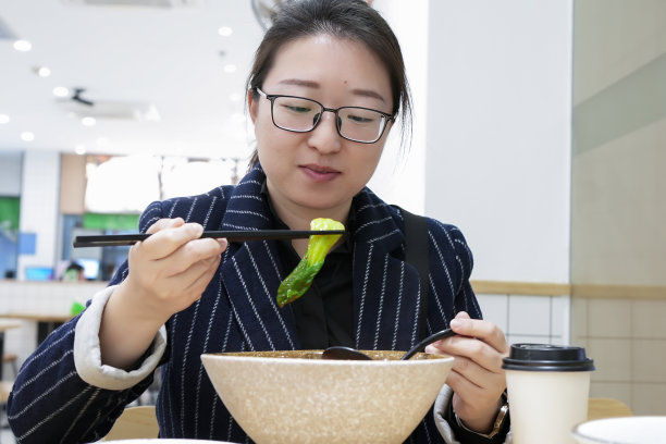 亚洲女性在店里吃素面图片下载