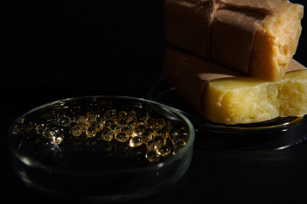 半透明凝胶胶囊与必需酸和油在实验室培养皿与有机肥皂条黑色图片下载