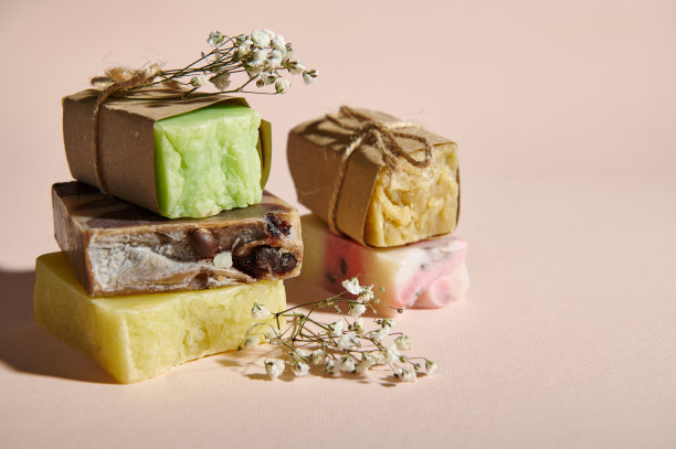 静物构图与各种天然有机肥皂在生态纸和吉卜草花，孤立的米色背景图片下载