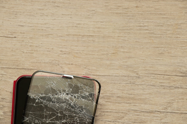 手机和破碎的钢化玻璃碰在一个隔离的背景上，更换玻璃图片下载