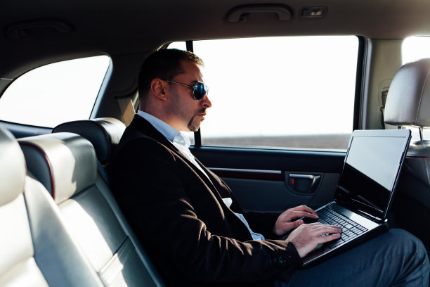 商人在车里用笔记本电脑工作图片下载