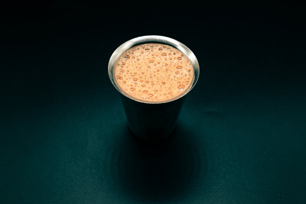 顶部视图的茶在一个银色玻璃杯，深绿色背景图片下载