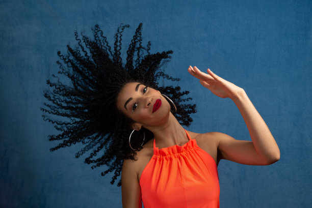 美丽的年轻女子做运动与她的头和头发。图片下载