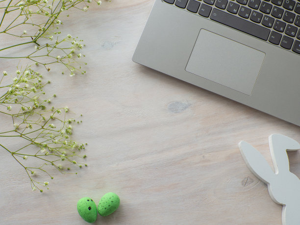 商务办公桌与笔记本电脑和绿色鸡蛋在白木背景图片下载