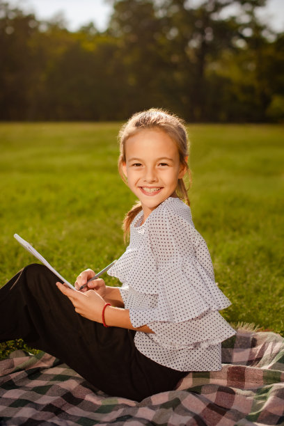 小女孩拿着课本在户外图片下载