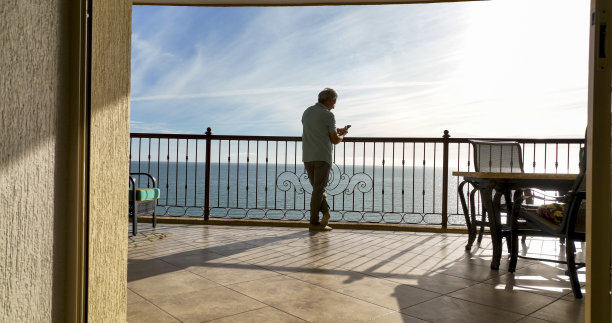 男子在海上阳台上使用手机图片下载