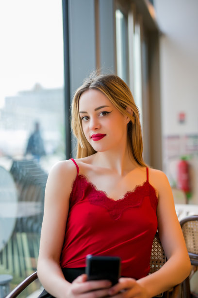 金发女人坐在酒吧里，收到男朋友的短信，很开心图片下载