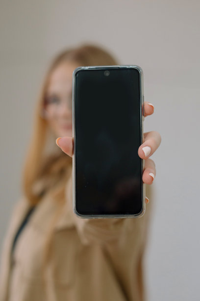 年轻女子手里拿着手机特写。手机屏幕空白。遥远的工作。学生。自由职业者。图片下载