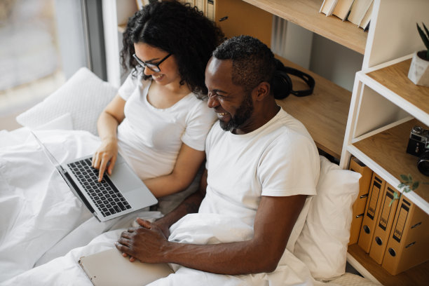 微笑的家庭运行笔记本电脑在枕头在公寓图片下载