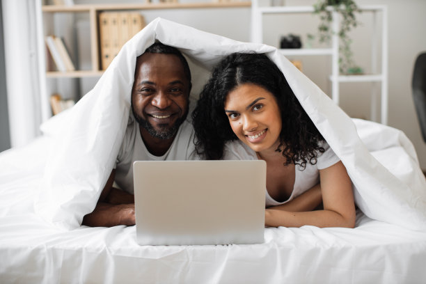 幸福的两个家庭在家里玩笔记本电脑图片下载