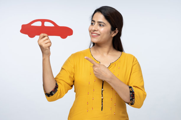 照片的年轻积极妇女持有汽车符号孤立在白色背景的股票照片图片下载