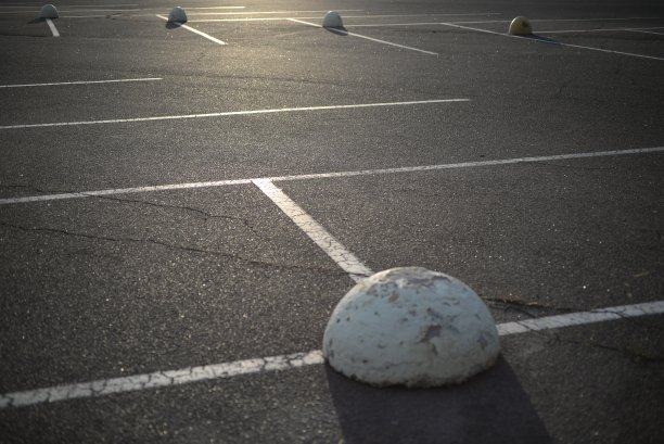 混凝土交通限制标志涂成白色的混凝土标志，停车位，混凝土道路上对称的线条，安装在沥青上的混凝土半球，白色交通锥的混凝土停车半球图片下载