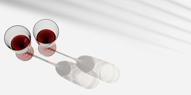 最小的夏日场景与一杯红酒，阳光阴影在白色背景，复制空间，酒杯平铺。两个酒杯，酒精饮料的照片。假期，派对，活动概念图片下载