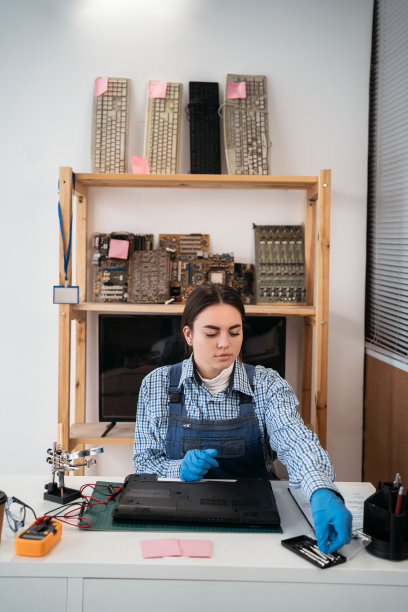 在维修车间用螺丝刀拆卸笔记本电脑。笔记本电脑维修。拆卸电脑图片下载