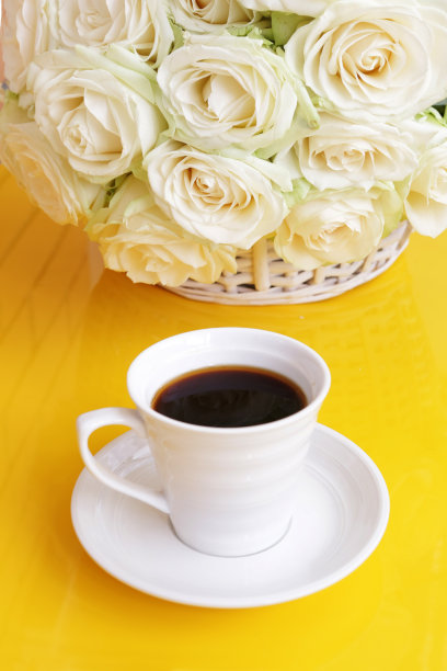 黑咖啡和白玫瑰在黄色桌子上的特写照片图片下载