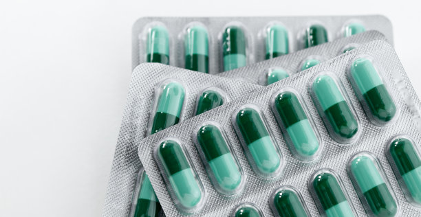 一堆绿色的药丸。塑料包装的药丸。保健和医学的概念。图片下载