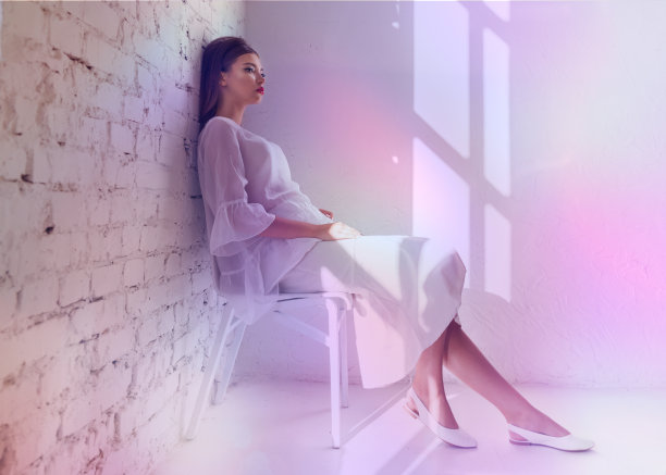 年轻女子的霓虹灯肖像。影棚拍摄。模特在紫色、红色和粉色灯光下摆姿势。图片下载