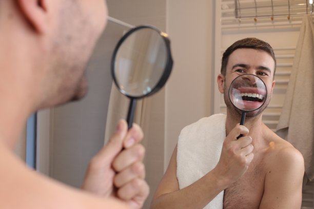 一个男人正在分析他的牙齿健康状况图片下载