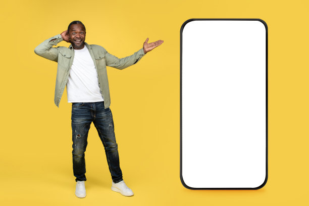 惊讶的微笑成年非洲裔美国男性在随意显示与手巨大的智能手机与空屏幕图片下载