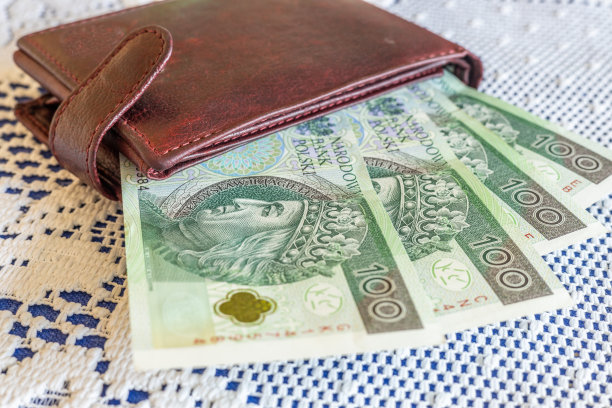 白色桌布上的桌子上有一个棕色钱包，里面有波兰货币，家庭预算和财务概念，100兹罗提钞票图片下载