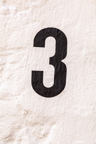 3数字装饰字体用黑色油漆手绘在白色油漆水泥渲染的房子墙壁上。图片下载