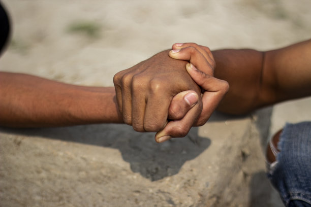 两个年轻人握紧拳头扭打，背景模糊图片下载